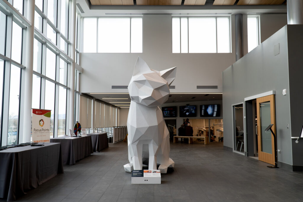 White cat sculpture in a building lobby.